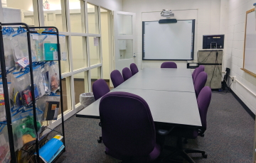Curriculum lab with table, smart screen, podium, and educational materials